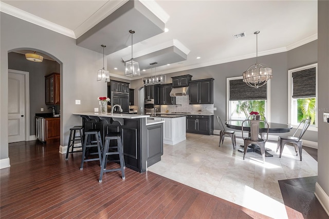 kitchen with decorative light fixtures, kitchen peninsula, a breakfast bar area, and tasteful backsplash