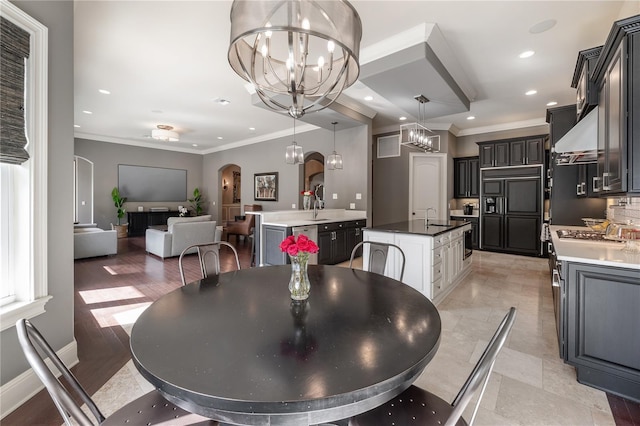 dining space featuring crown molding, sink, and a chandelier