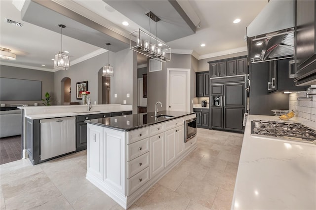 kitchen with pendant lighting, white cabinets, built in appliances, sink, and ornamental molding