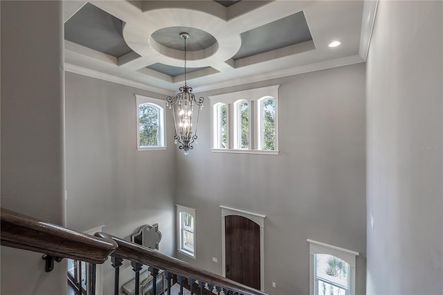 interior space featuring coffered ceiling, a chandelier, and ornamental molding