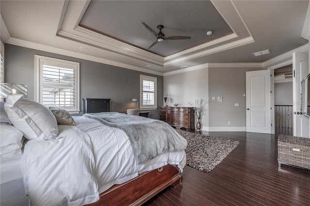 bedroom featuring ornamental molding, dark wood-type flooring, ceiling fan, and a raised ceiling