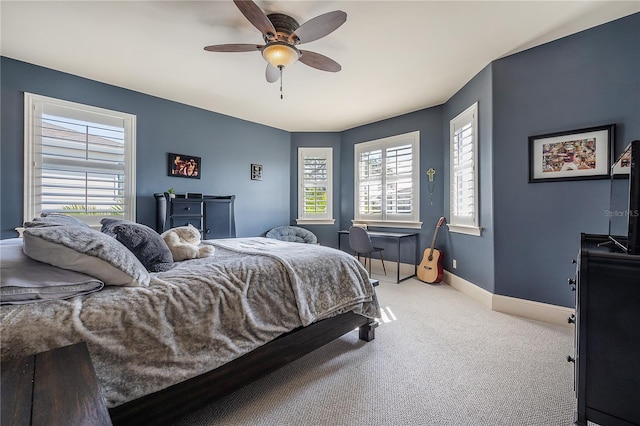 carpeted bedroom featuring ceiling fan and multiple windows