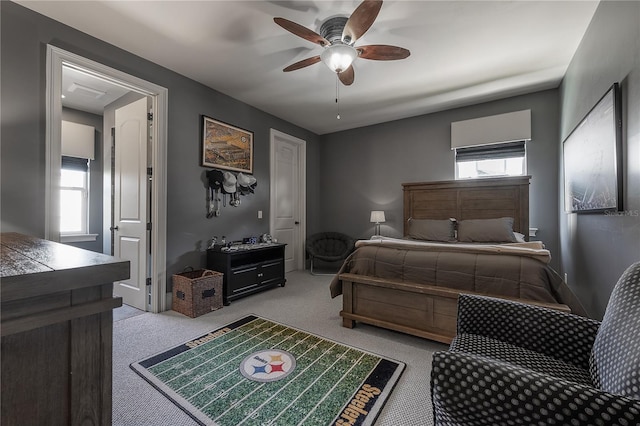 carpeted bedroom featuring multiple windows and ceiling fan