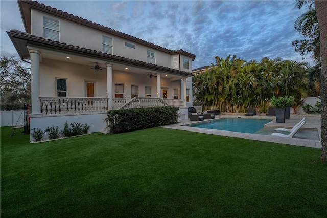 back of house with a fenced in pool, a patio area, a lawn, and ceiling fan