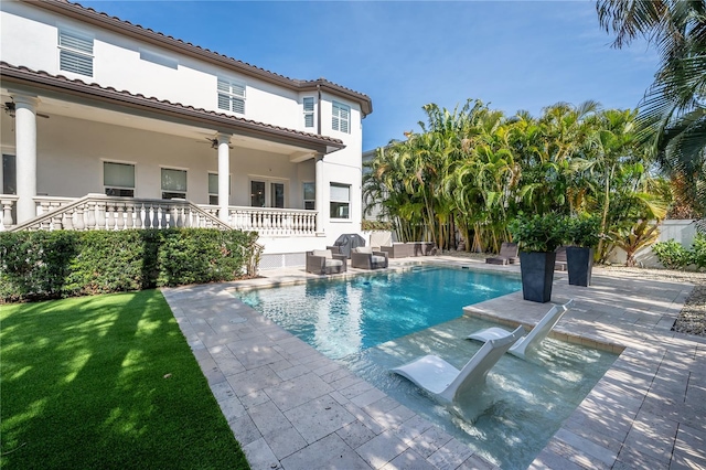 view of swimming pool with ceiling fan and a patio area