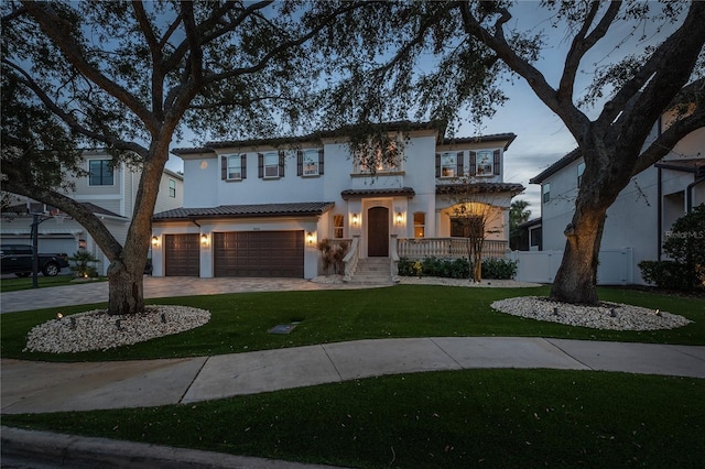 mediterranean / spanish house featuring a garage and a front lawn