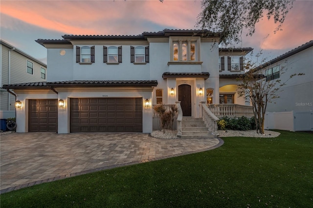 mediterranean / spanish-style house featuring a lawn and a garage