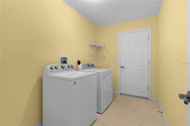 laundry room featuring washer and dryer and a textured ceiling