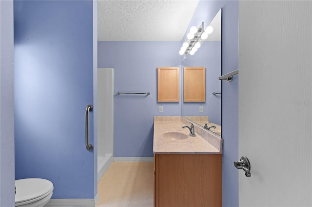 bathroom with vanity, a shower, a textured ceiling, and toilet