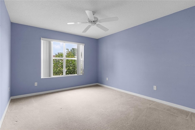 carpeted spare room with ceiling fan and a textured ceiling