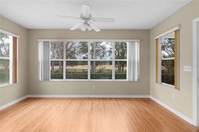 spare room featuring ceiling fan, a textured ceiling, and light hardwood / wood-style flooring