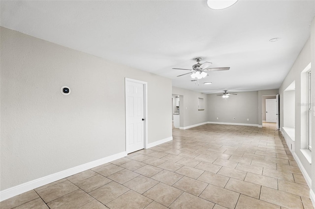 empty room with ceiling fan and light tile patterned flooring