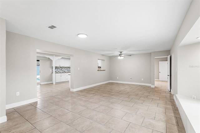 tiled spare room with ceiling fan