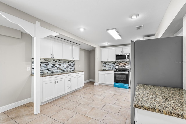 kitchen featuring tasteful backsplash, white cabinetry, appliances with stainless steel finishes, and dark stone counters