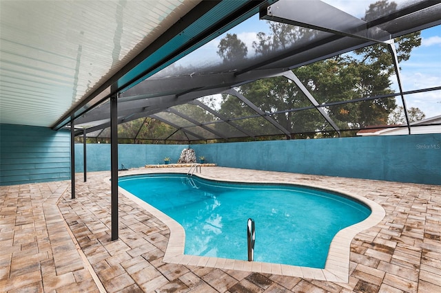 view of swimming pool featuring a patio and glass enclosure