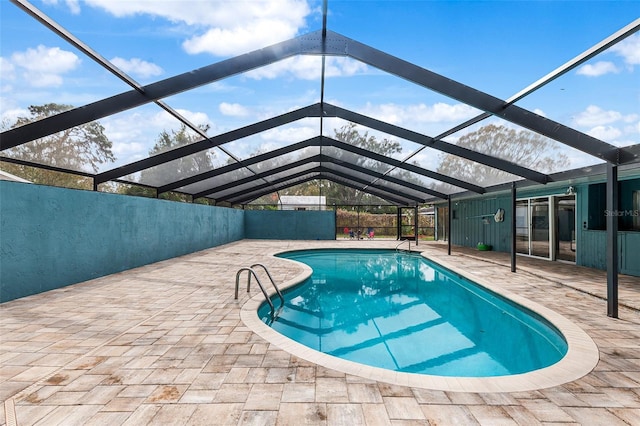 view of swimming pool featuring a patio and glass enclosure