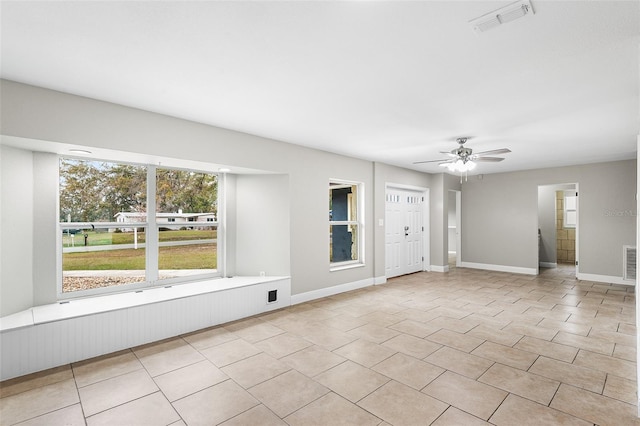 tiled empty room featuring ceiling fan