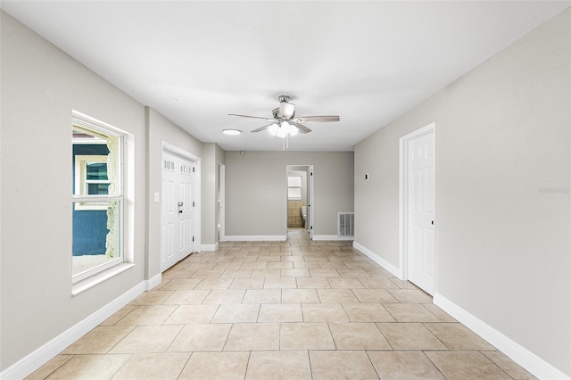 tiled spare room with ceiling fan