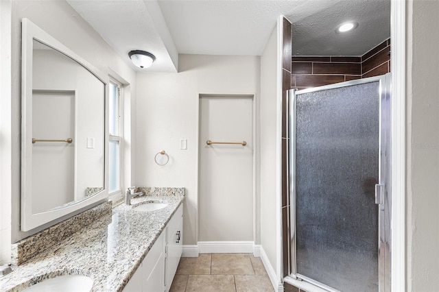 bathroom featuring vanity, tile patterned floors, a textured ceiling, and walk in shower