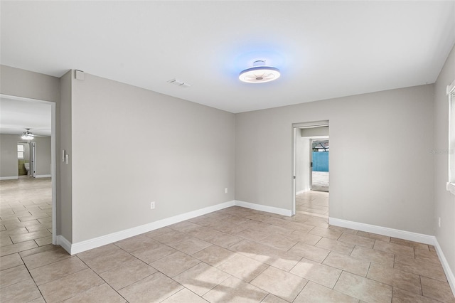 tiled spare room with ceiling fan