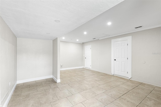 basement with a textured ceiling and light tile patterned flooring