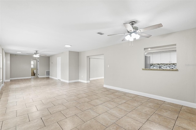 tiled empty room featuring ceiling fan