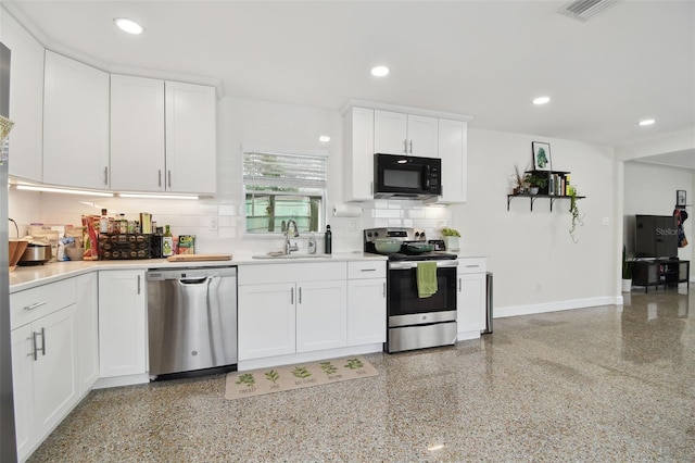 kitchen featuring white cabinets, backsplash, appliances with stainless steel finishes, and sink