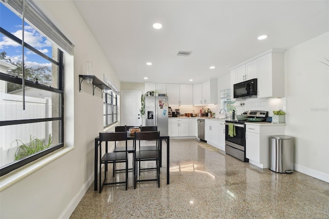 kitchen featuring sink, tasteful backsplash, white cabinetry, and appliances with stainless steel finishes