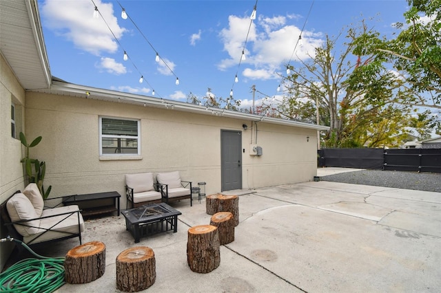 back of house featuring a patio and an outdoor living space with a fire pit