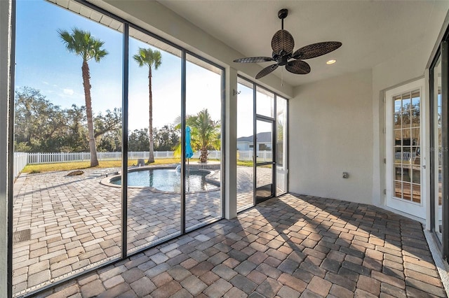 unfurnished sunroom with a ceiling fan