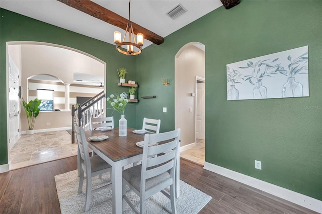 dining space featuring visible vents, beamed ceiling, baseboards, and wood finished floors