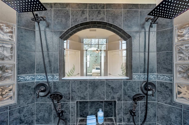 interior space with arched walkways and a tile shower