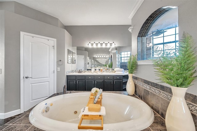 full bath featuring baseboards, vanity, and a whirlpool tub