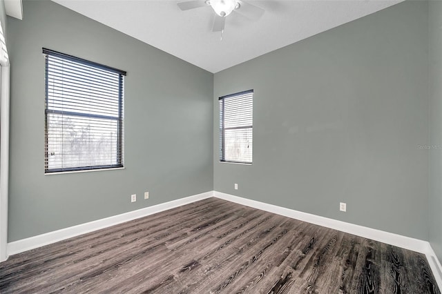 empty room featuring ceiling fan, vaulted ceiling, baseboards, and dark wood finished floors