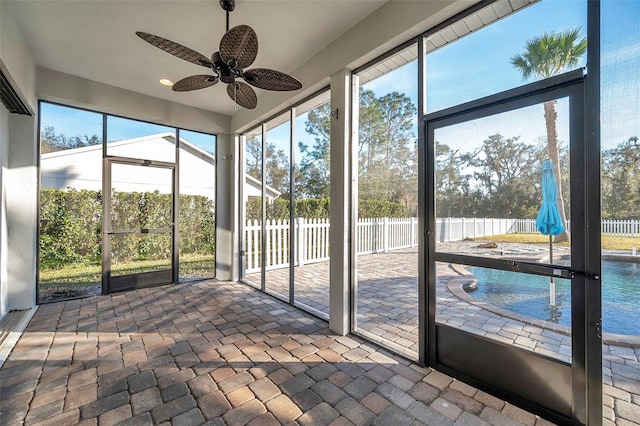 unfurnished sunroom with ceiling fan