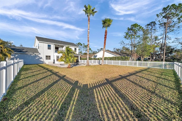 view of yard featuring a fenced backyard and a balcony