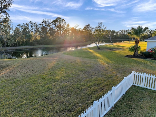 view of yard featuring a water view and fence