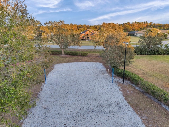 view of property's community with volleyball court and a lawn