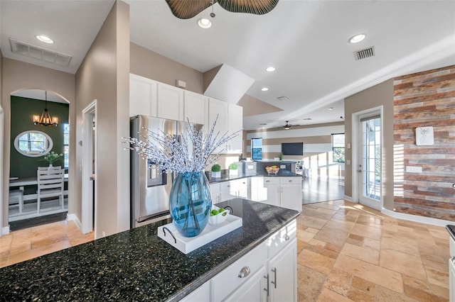 kitchen featuring a peninsula, ceiling fan with notable chandelier, stainless steel fridge with ice dispenser, and visible vents