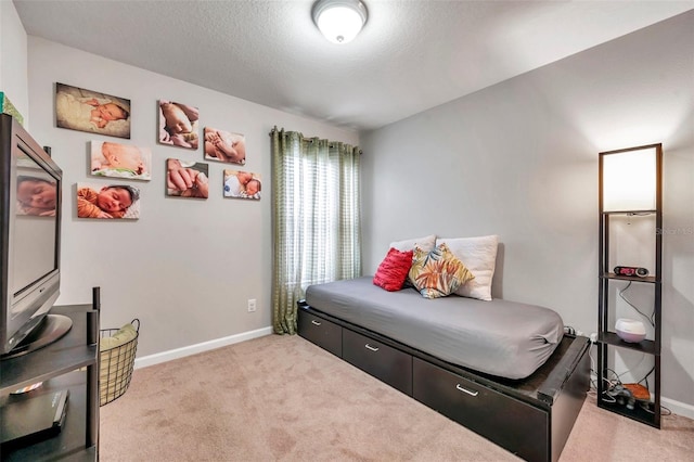 bedroom with light colored carpet and a textured ceiling