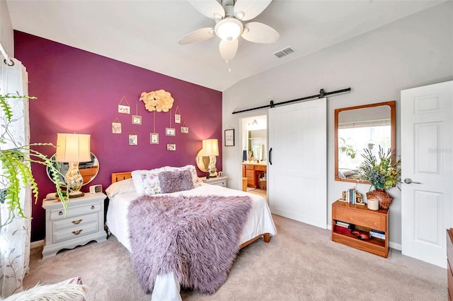 bedroom featuring lofted ceiling, light colored carpet, ceiling fan, a barn door, and ensuite bath