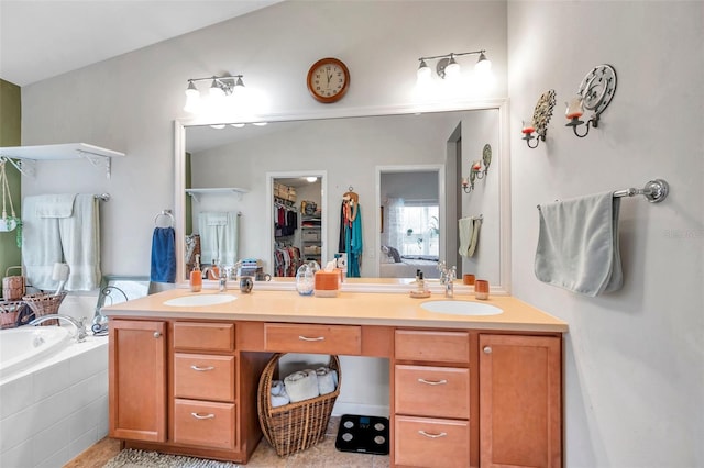 bathroom with vanity, vaulted ceiling, and tiled bath