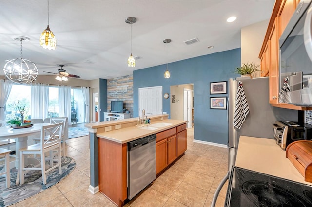 5720 107th Ter E, Parrish, FL 34219 - kitchen with stainless steel appliances, brown cabinets, ceiling fan, light countertops, and light tile patterned floors