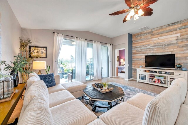 5720 107th Ter E, Parrish, FL 34219 - tiled living room featuring wooden walls, vaulted ceiling, ceiling fan, and an accent wall