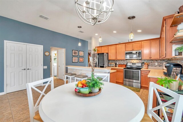5720 107th Ter E, Parrish, FL 34219 - kitchen featuring appliances with stainless steel finishes, backsplash, a chandelier, light countertops, and a kitchen island with sink