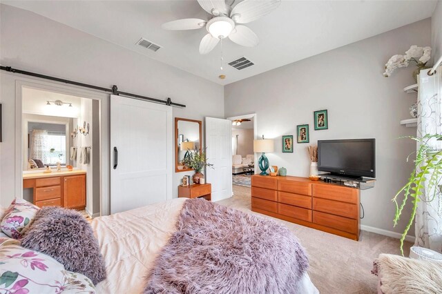 5720 107th Ter E, Parrish, FL 34219 - bedroom featuring a barn door, light carpet, ceiling fan, and ensuite bath
