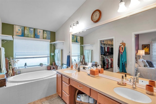 5720 107th Ter E, Parrish, FL 34219 - full bathroom featuring a bath, vaulted ceiling, double vanity, tile patterned floors, and a spacious closet