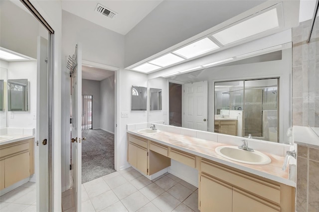 bathroom featuring tile patterned flooring, vanity, and a skylight