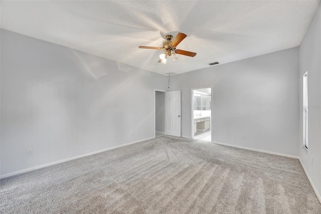 spare room featuring ceiling fan, light carpet, and a textured ceiling