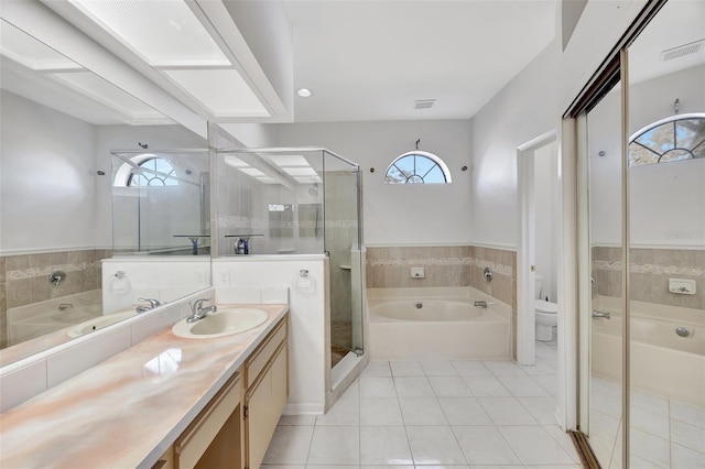 full bathroom with tile patterned floors, toilet, independent shower and bath, and vanity